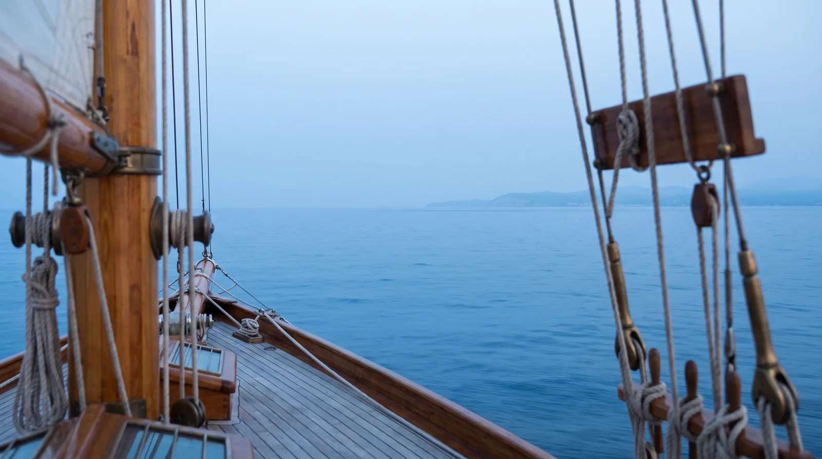 Voilier au large, la côte s'éloigne à l'horizon